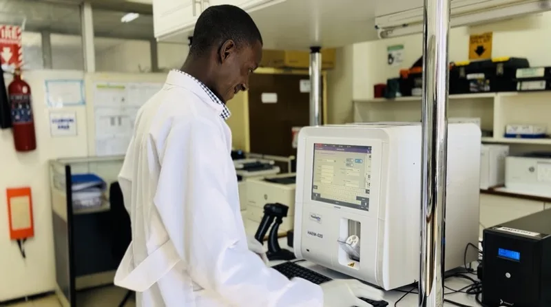 Laboratory technologist operating automated Yumizen hematology diagnostic analyzer